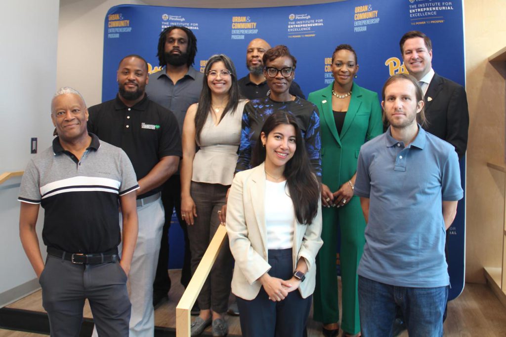 A group of people in front of a blue step and repeat background